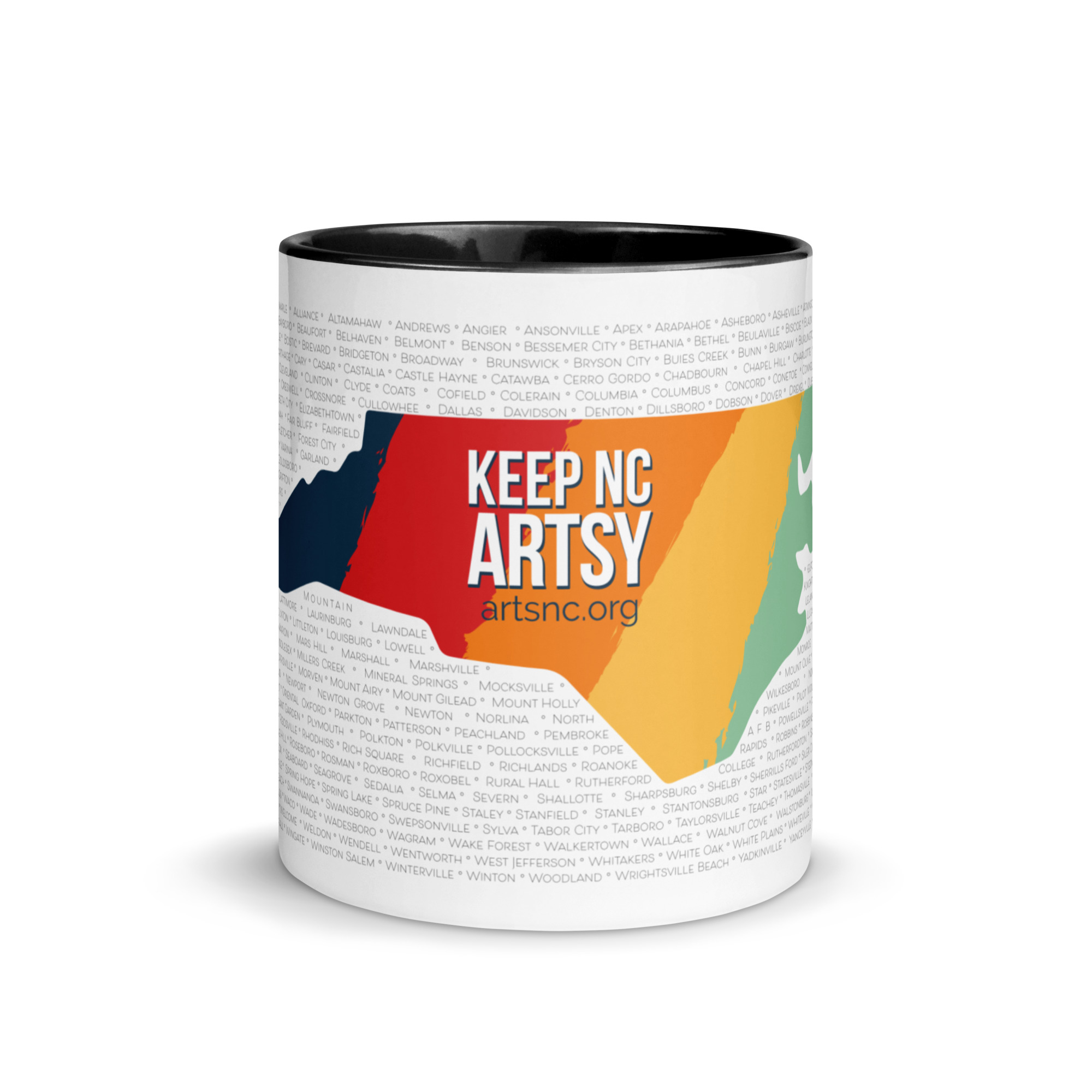 A white mug with black inside and a black handle. The outside of the mug is printed with NC state shape that has five vertical stripes - blue, red, orange, yellow and light green. Text in the center says "Keep NC Artsy". In the background are rows of NC county and city names.