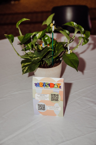 ARTS Day 2023 Tables- image of plant, tabletop and table tent with information