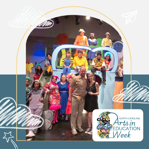 Picture of Kirsta Stewart accepting her award in front of a group of her students in colorful costumes.