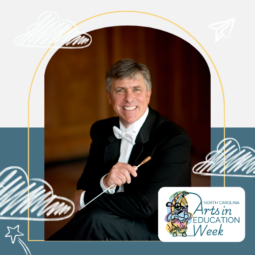 Picture of Scott Laird. A white man with brown hair with grey on the sides. He is wearing a tuxedo and holding a conductor's baton.